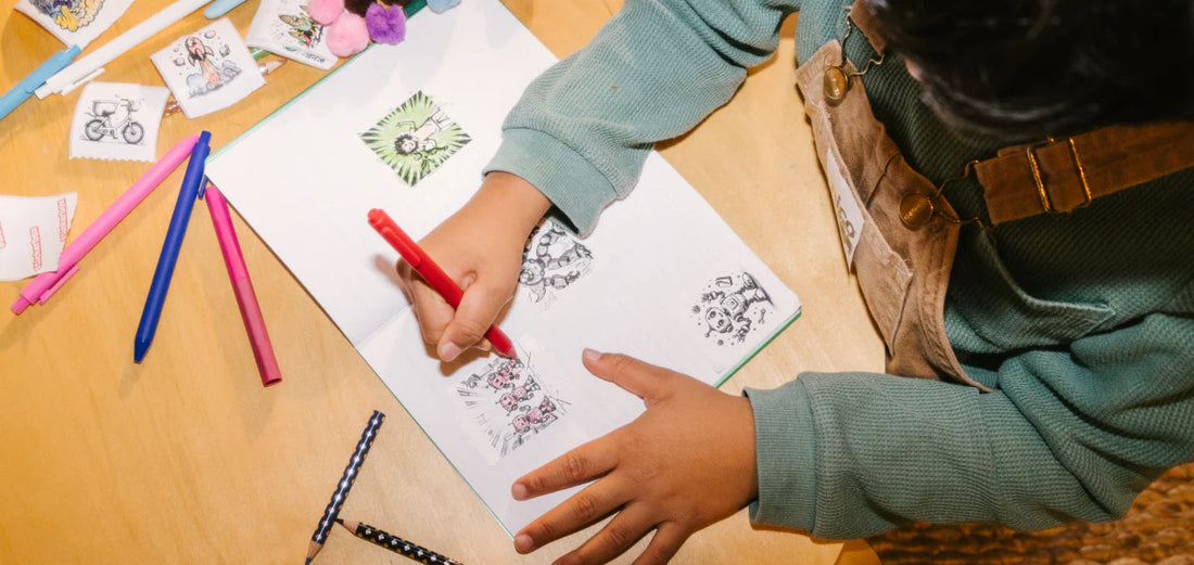 a boy coloring his stickers on a table