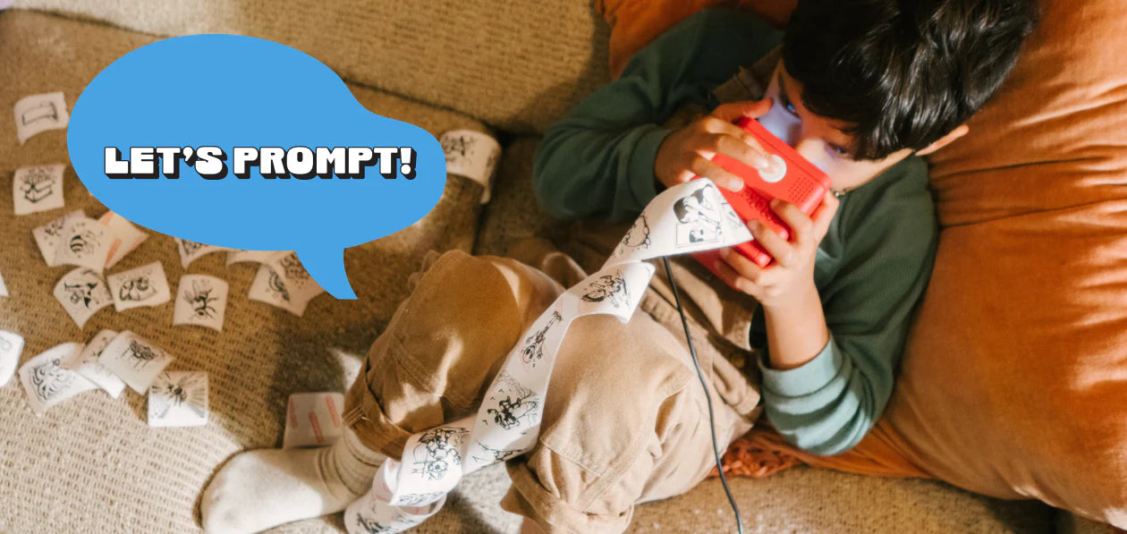 A child holding and talking into Stickerbox. There is a text next to him that says "Let's Prompt!" 