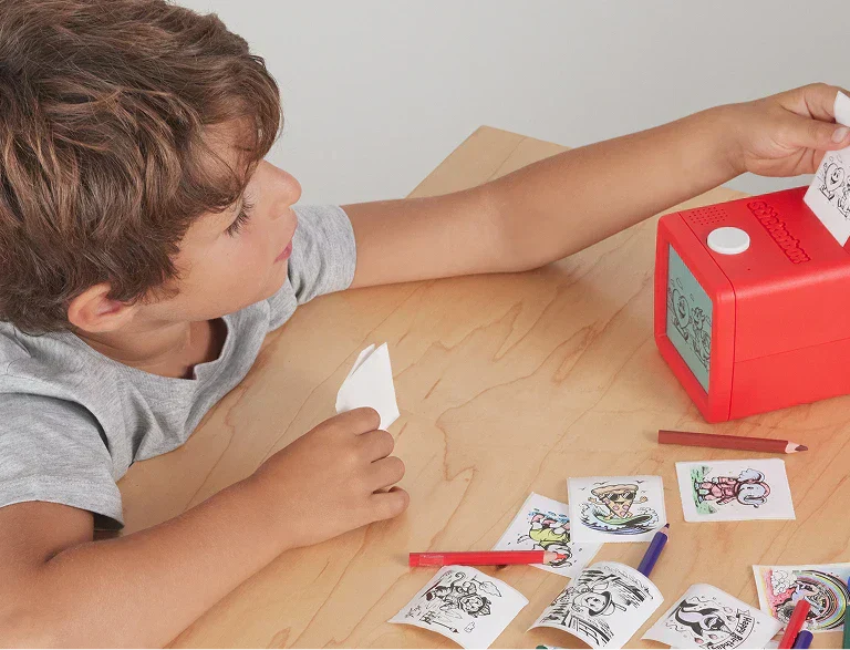 A child looking at printed stickers from Stickerbox.